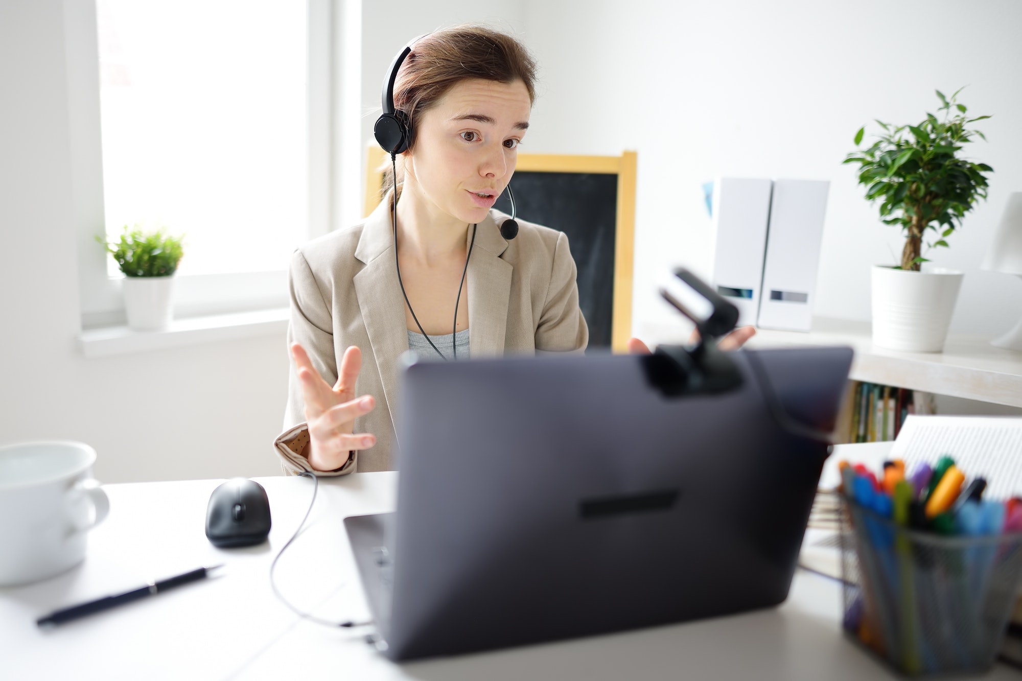 young-woman-is-learning-language-with-laptop-computer-camcorder-and-headphone-online-at-home-1-1